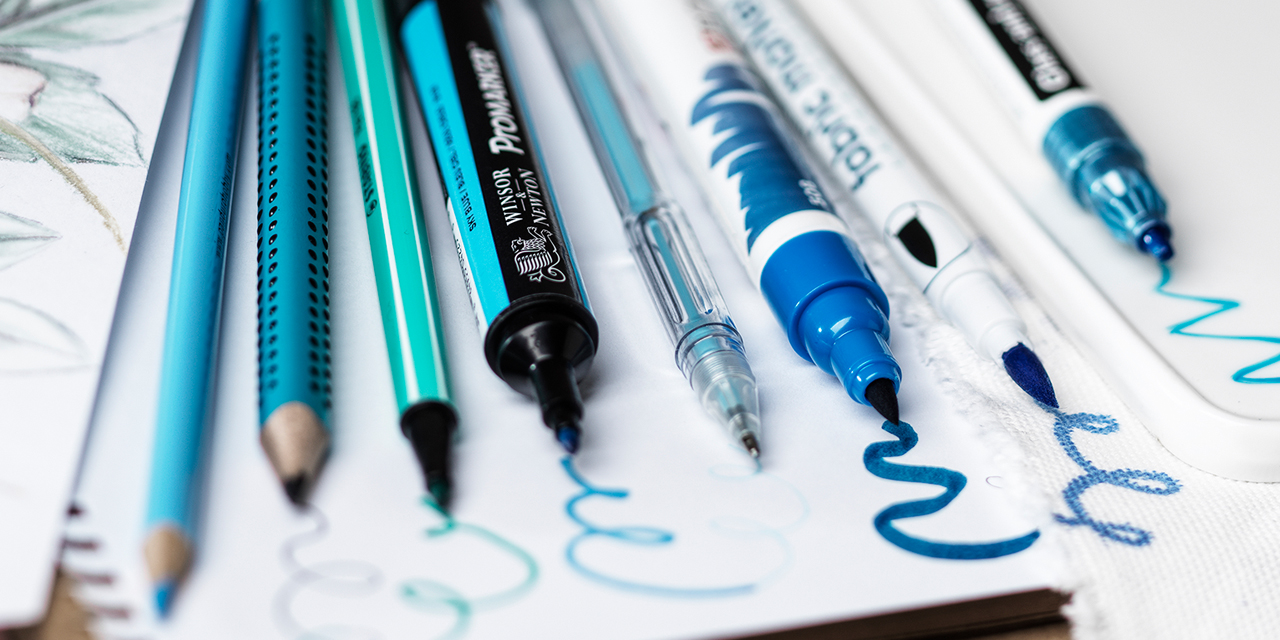 En samling blå pennor på vita pappersark