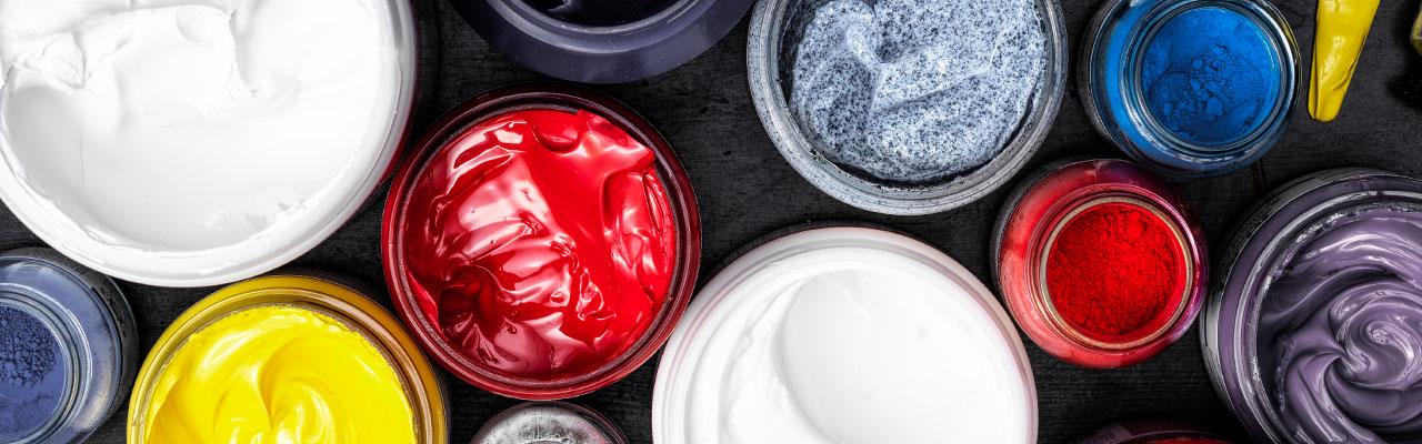 En bild med öppna burkar som innehåller olika typer av akrylfärg och mixed media.